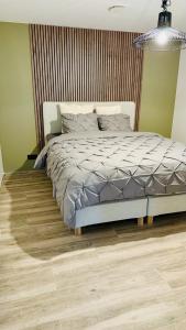 una camera con letto e pavimento in legno di Le Cocon a Embourg