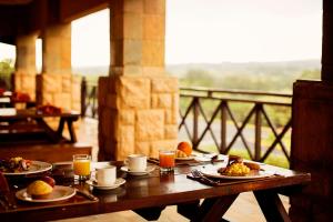a wooden table with plates of food and drinks on it at Ocean View Villas - F6 in Port Edward