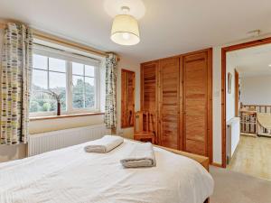 a bedroom with a large white bed with a window at 1 Bed in Sidmouth HAYES in Newton Poppleford