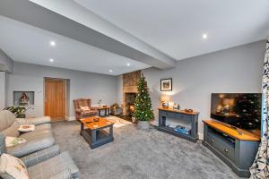 a living room with a christmas tree and a couch at Finest Retreats - Moorfield House in Bishop Thornton
