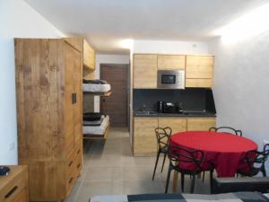 Il comprend une chambre et une cuisine avec une table et des chaises rouges. dans l'établissement Petite Maison Larice, à Pila