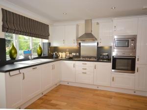 a kitchen with white cabinets and a sink at 4 Bed in Bideford NILGA in Bideford