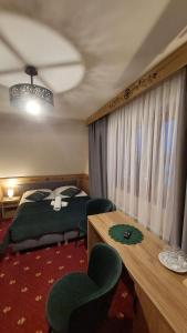 1 dormitorio con 1 cama, mesa y sillas en Willa u Kośle Zakopane, en Zakopane