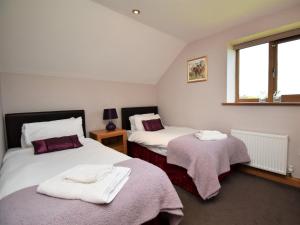 a bedroom with two beds with towels on them at 3 Bed in Ironbridge HWLOC in Buildwas