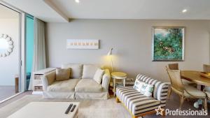 a living room with a couch and a table at Number 1 H Residences - WiFi, Parking & More by Gold Coast Holidays in Gold Coast