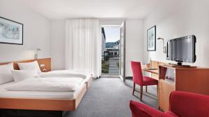 a hotel room with a bed and a tv at Landhotel Beck in Kupferzell