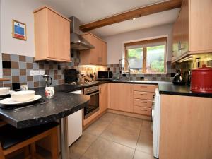 a kitchen with wooden cabinets and a black counter top at 3 Bed in Ironbridge HWLOC in Buildwas