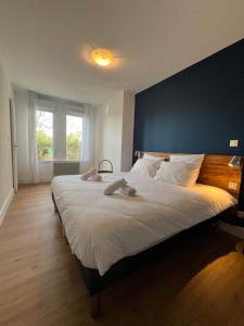 - une chambre avec un grand lit et un mur bleu dans l'établissement Les appartements du Clos de la Chartreuse By Ateya, à Aix-en-Provence