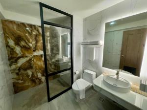 a bathroom with a sink and a toilet and a mirror at Keereen Resort - Ao Nang Krabi in Ao Nang Beach