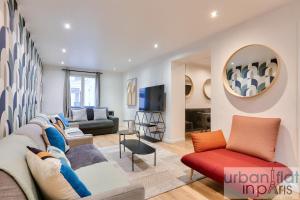 uma sala de estar com um sofá e uma televisão em Urban Flat 103 - Spacious Flat near Grands Boulevards em Paris