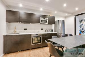 a kitchen with a table and a counter top at Urban Flat 103 - Spacious Flat near Grands Boulevards in Paris