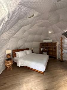 sypialnia z łóżkiem i białą ścianą w obiekcie Lhong Chiang Dao Glamping หลงเชียงดาว w mieście Chiang Dao