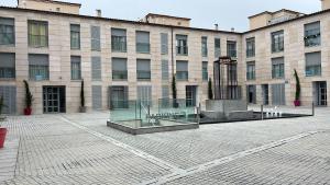 a large brick building with a glass building at Apartamento Punto24 con acceso a Parking in Cáceres