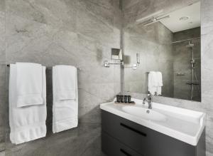 un bagno bianco con lavandino e specchio di Hotel Grimsborgir by Keahotels ad Ásborgir