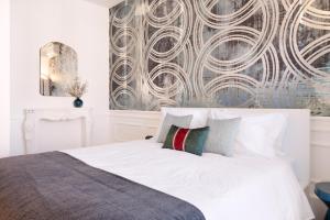 een slaapkamer met een wit bed en een muurschildering bij Historical Penthouse at Cardosas Block in Porto