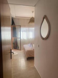 a bedroom with a bed and a mirror on the wall at Bel appart wifi balcon et parking Marrakech centre in Marrakesh
