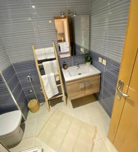 ein Badezimmer mit einem WC, einem Waschbecken und einem Spiegel in der Unterkunft Bel appart wifi balcon et parking Marrakech centre in Marrakesch