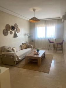 ein Wohnzimmer mit einem Sofa und einem Couchtisch in der Unterkunft Bel appart wifi balcon et parking Marrakech centre in Marrakesch