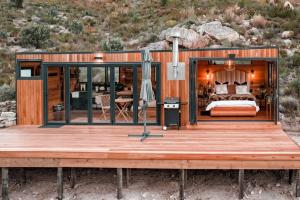 a cabin with a bed on a wooden deck at Luxury Solace Cabin - River Cabin in Rawsonville