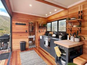 a kitchen with wood paneling and a stove in a room at Luxury Solace Cabin - River Cabin in Rawsonville