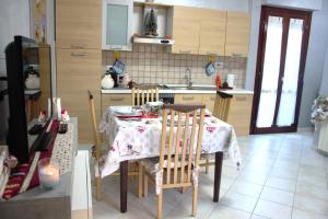 een keuken met een tafel en stoelen met een tafel en een keuken bij The Golden Houre House near the sea in Torvaianica