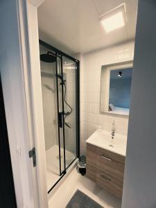 um banheiro com chuveiro e pia em Studio Sarah em De Panne