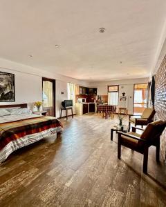 Un dormitorio con una cama y una sala de estar. en La Casa del Cerro, en Sucre