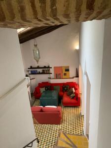 salon z czerwoną kanapą i czerwonym krzesłem w obiekcie La Calleja w mieście Cazalla de la Sierra