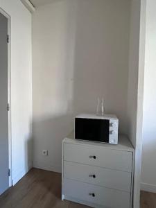 a white dresser with a microwave on top of it at Studio neuf au calme proche gare maritime - 7 min in Nantes