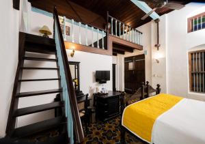 Un dormitorio con una cama elevada y una escalera en Bloom Boutique Waterfront Fort Kochi, en Kochi