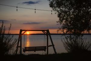 un columpio con la puesta de sol en el fondo en Camping Szczecinek Domy Wypoczynkowe en Szczecinek