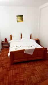 a bed with white sheets and pillows in a room at Casa Schi in Straja