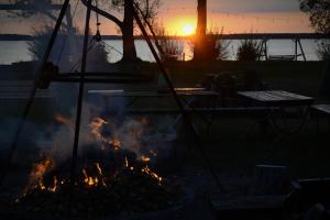 eine Feuerstelle mit Sonnenuntergang im Hintergrund in der Unterkunft Camping Szczecinek Domy Wypoczynkowe in Szczecinek