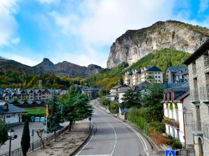 eine Straße in einer Stadt mit Bergen im Hintergrund in der Unterkunft Apartamentos 3000 Escarrilla in Escarrilla