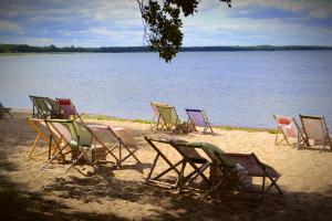 - un groupe de chaises longues assises sur la plage dans l'établissement Camping Szczecinek Domy Wypoczynkowe, à Szczecinek