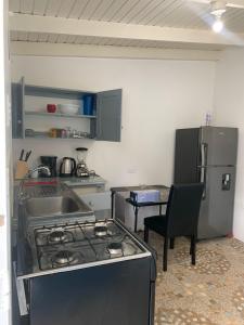 a kitchen with a stove and a sink and a table at Lovely Studio Apt in Whim Estate-near Scarborough in Scarborough