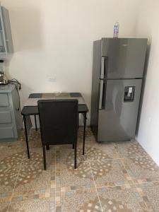 a kitchen with a table and a refrigerator at Lovely Studio Apt in Whim Estate-near Scarborough in Scarborough