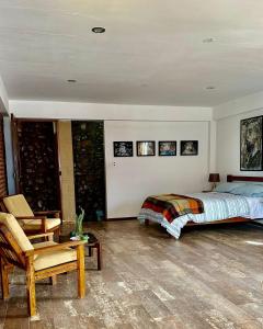 a bedroom with a bed and a chair at La Casa del Cerro in Sucre