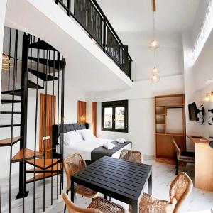 een woonkamer met een bed en een tafel met stoelen bij ACTA Luxury Rooms in Nikiti