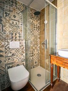 e bagno con doccia, servizi igienici e lavandino. di Hôtel Candide a Saint-Bertrand-de-Comminges