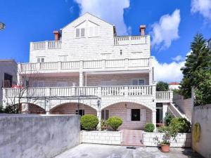 um grande edifício de tijolos brancos com uma varanda em City Apartments Lani em Dubrovnik