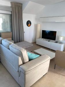 a living room with a couch and a tv at Nuestro Sueño in Orihuela Costa