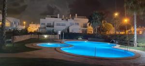 a swimming pool in front of a building at night at Nuestro Sueño in Orihuela Costa