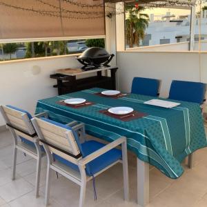 a table with blue chairs and a green table cloth at Nuestro Sueño in Orihuela Costa