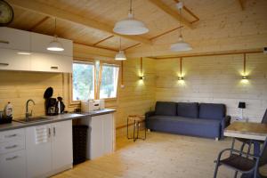 a kitchen and living room with a blue couch in a room at Camping Szczecinek Domy Wypoczynkowe in Szczecinek