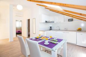 City Apartments Lani في دوبروفنيك: مطبخ وغرفة طعام مع طاولة وكراسي