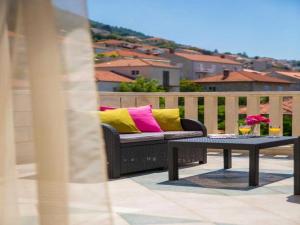 a couch with colorful pillows sitting on a balcony at City Apartments Lani in Dubrovnik