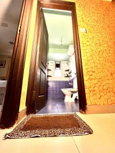 a bathroom with aoyer with a door and a rug at Remarkable 3-Bed Apartment in Panjim in Panaji