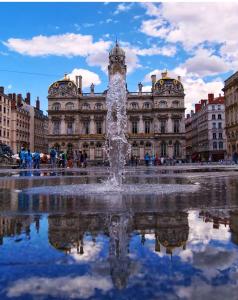 einen Brunnen vor einem großen Gebäude in der Unterkunft Celect'in Lyon in Lyon