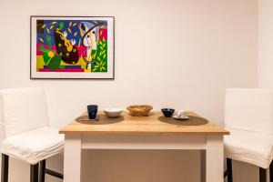 a table with two chairs and a painting on the wall at Les Létruns - Appart - 4 pers - Vue sur la mer in Saint Malo